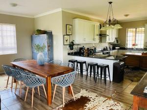 a kitchen with a wooden table and some chairs at Kerriston Guest House in Mooiriver