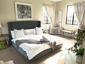 a bedroom with a large bed in a room with windows at Kerriston Guest House in Mooirivier