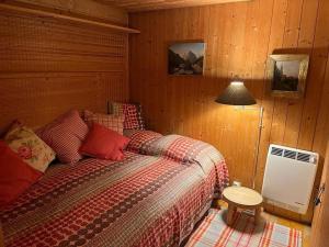 a bedroom with a bed and a table and a lamp at Le Fayard vue Lac in Publier