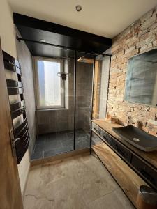 La salle de bains est pourvue d'une douche avec une porte en verre. dans l'établissement La suite de charme du Mas de la Fontaine de Jonquier avec SPA privatif, à Séguret