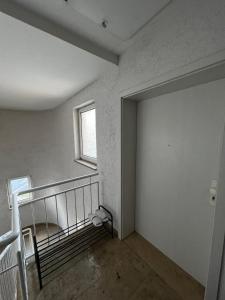 an empty room with a staircase and a window at Ferienwohnung Coburger Land, ländlich gut gelegen in Meeder
