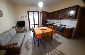 eine Küche und ein Esszimmer mit einem Tisch und einem Sofa in der Unterkunft Casa vacanze Tommasone in Custonaci