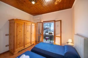 a bedroom with a blue bed and a window at Casa la noce Positano in Positano