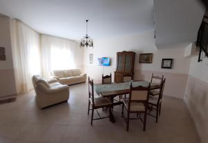 ein Wohnzimmer mit einem Tisch, Stühlen und einem Sofa in der Unterkunft Casa vacanze Tommasone in Custonaci