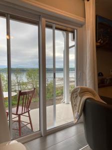 um quarto com uma porta de vidro deslizante e vista para a praia em Suite 2, Flèche du fjord, vue Saguenay, Mont Valin em Saint-Fulgence