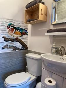 La salle de bains est pourvue de toilettes et d'une peinture murale représentant un oiseau. dans l'établissement Suite 2, Flèche du fjord, vue Saguenay, Mont Valin, à Saint-Fulgence