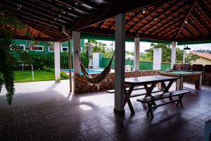 um pátio com uma rede de descanso, uma mesa e cadeiras em Casa familiar com piscina Penedo RJ em Penedo