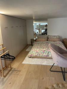 a bedroom with a bed and a chair in it at לופט משגע במיקום מרכזי ברמת גן in Ramat Gan