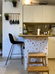 a kitchen with a counter with a chair and a table at לופט משגע במיקום מרכזי ברמת גן in Ramat Gan