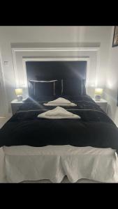 a bedroom with a large black bed with two lamps at THE CRESCENT in Rhyl