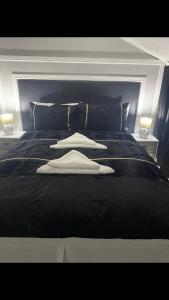 un letto nero con tre asciugamani bianchi sopra di THE CRESCENT a Rhyl