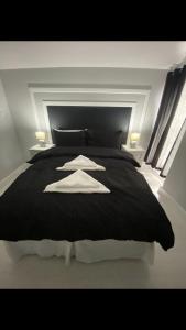 a bedroom with a black bed with two towels on it at THE CRESCENT in Rhyl