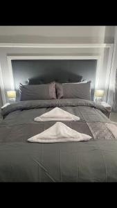 ein Schlafzimmer mit einem Bett mit zwei Handtüchern darauf in der Unterkunft THE CRESCENT in Rhyl