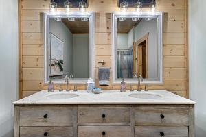 a bathroom with two sinks and two mirrors at New Luxury Vacation Home Cabin in Smoky Gatlinburg - Theater Room in Gatlinburg