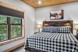 a bedroom with a bed and two windows at New Luxury Vacation Home Cabin in Smoky Gatlinburg - Theater Room in Gatlinburg