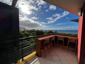 een balkon met stoelen en uitzicht op de oceaan bij Nouveauté Sunset appart vue exceptionelle in Saint-Denis