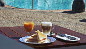 a table with two glasses of beer and a plate of sandwiches at Bungalows Los Almendros - Exclusive Vacation Club in Playa del Ingles