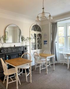 une salle à manger avec une table, des chaises et une cheminée dans l'établissement The Dozy Deer, à Windermere