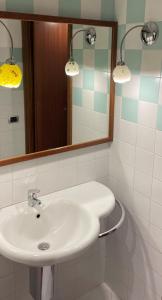 ein Badezimmer mit einem weißen Waschbecken und einem Spiegel in der Unterkunft Appartamento S Giuliano Mse Piazza Brivio in San Giuliano Milanese