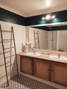 La salle de bains est pourvue de 2 lavabos et d'un grand miroir. dans l'établissement Domaine l'Oiseau Bleu, à Sainte-Maxime