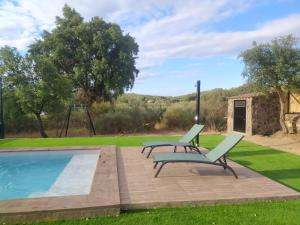 una piscina con 2 sillas y un columpio en Casa Rural La Vega, en San Vicente de Alcántara