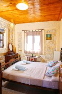 a bedroom with a large bed and a wooden ceiling at Stone House Irene in Hersonissos