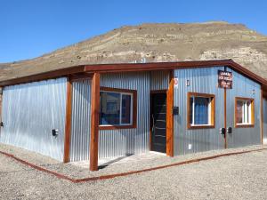 a metal building with a mountain in the background at Cabaña los Hielos in El Calafate