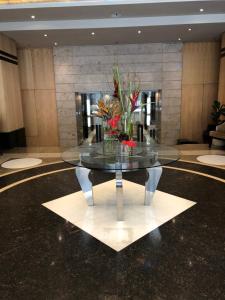 a glass table with flowers on it in a lobby at Michelangelo Towers 718 in Johannesburg