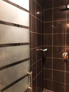 a bathroom with a shower with black tiles at Michelangelo Towers 718 in Johannesburg