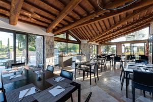 un restaurante con mesas, sillas y ventanas en Relais Le Ginestre, en Saturnia
