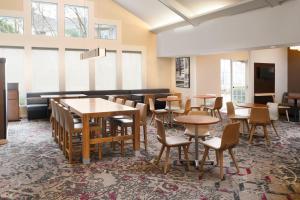 - une salle à manger avec des tables, des chaises et des fenêtres dans l'établissement Residence Inn Houston Westchase On Westheimer, à Houston