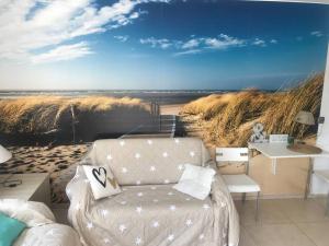 a living room with a couch and a beach mural at Apartament Wake&kite in Rewa