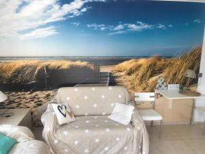a living room with a couch and a beach mural at Apartament Heniokite in Rewa