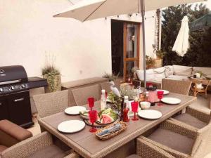 a table and chairs with a table and an umbrella at Apartament Heniokite in Rewa