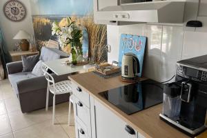 a kitchen with a counter top with a stove top oven at Apartament Heniokite in Rewa +6 photos
