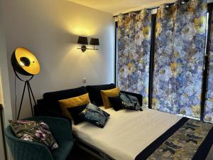 Schlafzimmer mit einem Bett und einem Fenster mit Vorhängen in der Unterkunft Gabrielle Appartements CANNES in Cannes