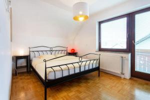 a bedroom with a bed and a large window at Farmhouse Apartment Happy Cow in Mavčiče