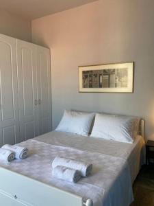 een slaapkamer met een bed met twee handdoeken erop bij Psamathe Aegina Apartments in Aegina Town