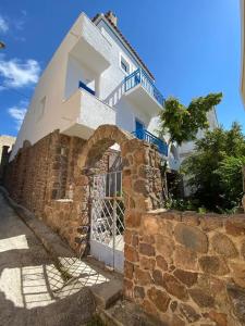 een gebouw met een poort en een stenen muur bij Psamathe Aegina Apartments in Aegina Town