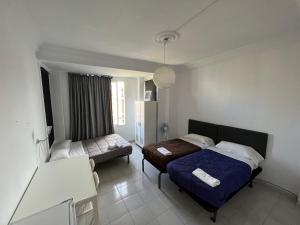 um quarto com duas camas e uma mesa em Rooms Valencia Center em Valência
