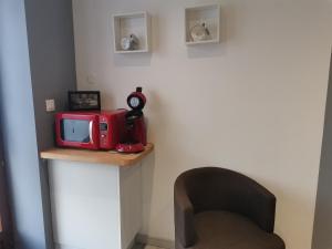 un forno a microonde rosso seduto su una mensola in una stanza di Le Pommiers a Pommiers-en-Forez