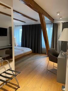 a bedroom with a bed and a desk and a chair at Landhotel Schlappinger-Hof in Reisbach