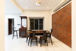 a dining room with a wooden table and chairs at Amminis Mansion by Doris Homes in Trichūr