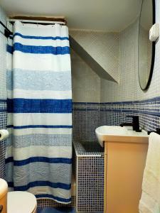 a bathroom with a shower curtain and a sink at Casa La Vikinga in Cudillero