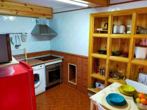 a kitchen with wooden cabinets and a red refrigerator at Casa La Vikinga in Cudillero