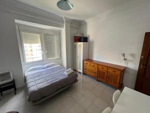 um quarto com uma cama, uma cómoda e uma janela em Rooms Valencia Center em Valência