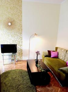 uma sala de estar com um sofá e uma mesa em Ratusha Apartments em Lviv