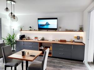 a dining room with a table and a tv on a wall at Armina's Residence in Dumbrăviţa