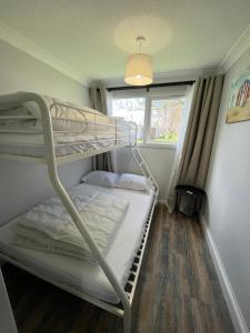 a bedroom with two bunk beds and a window at 88, Belle Aire, Hemsby - Two bed chalet, sleeps 5, bed linen and towels included - pet friendly in Great Yarmouth