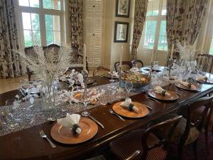 a wooden table with glasses and plates on it at Kerriston Manor House in Mooiriver